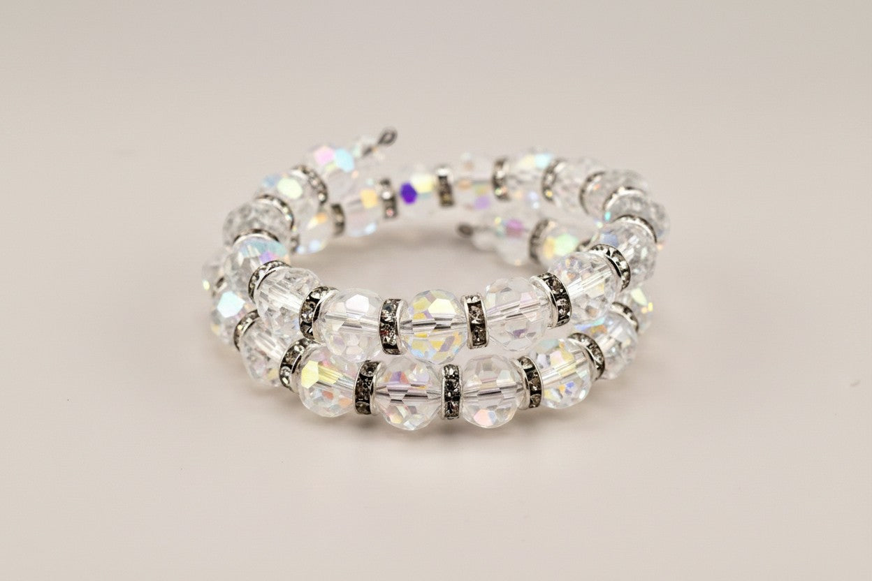 Calathea Collective iridescent crystal wrap bracelet with silver-tone rhinestone spacers. Faceted beads shimmer with pink, blue, and gold hues.