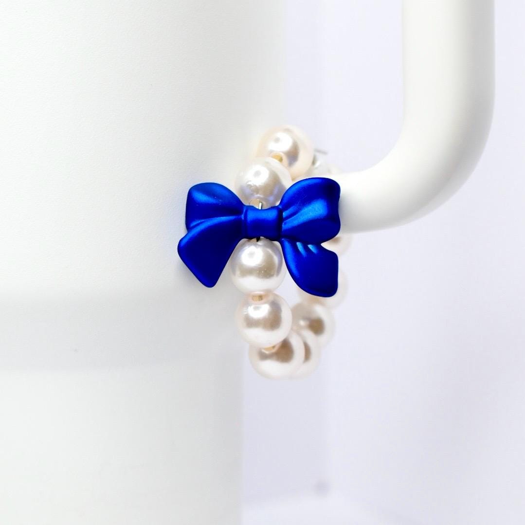 White Stanley with blue bow and pearls on a white background