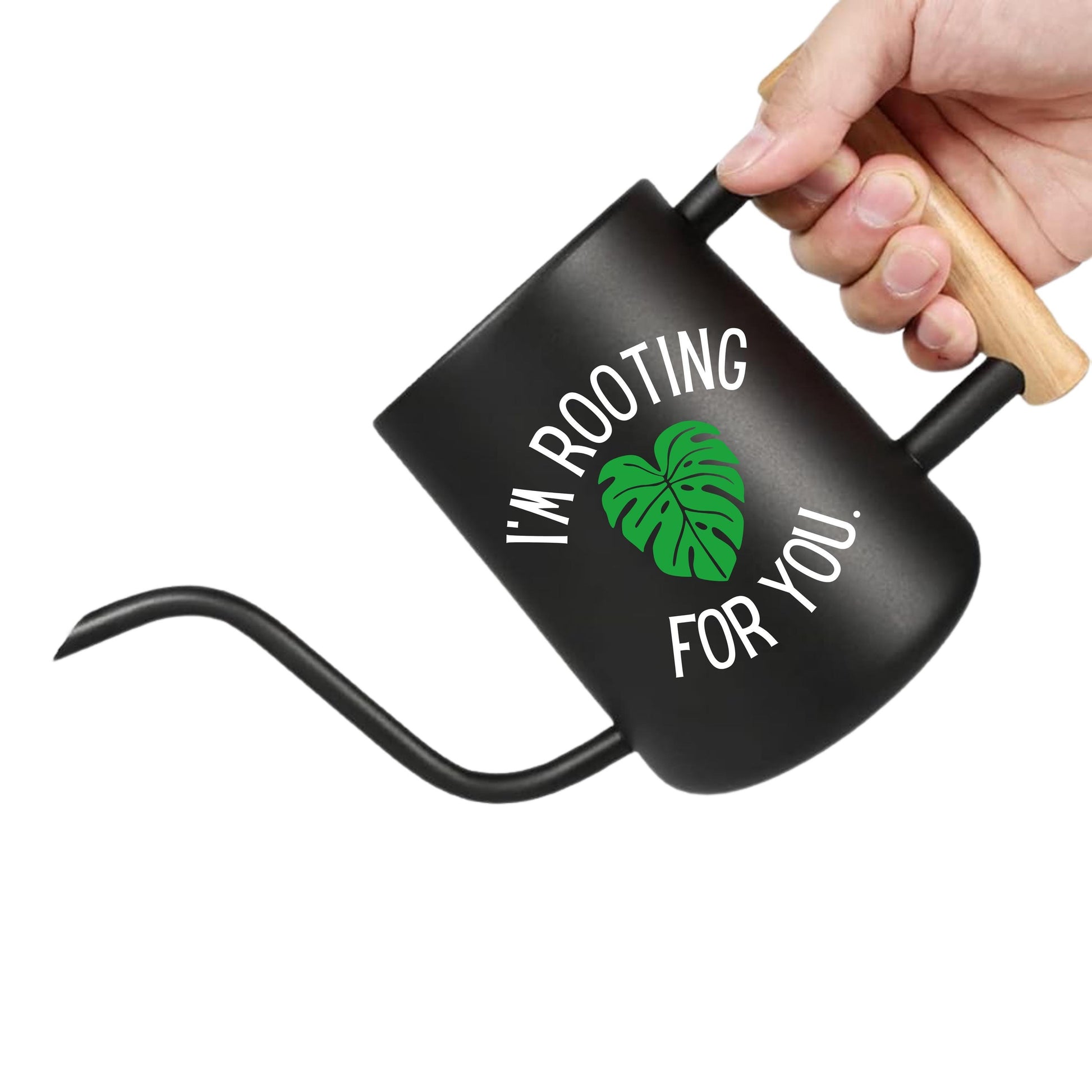 Black watering can with text and a leaf graphic, held by a hand on a white background