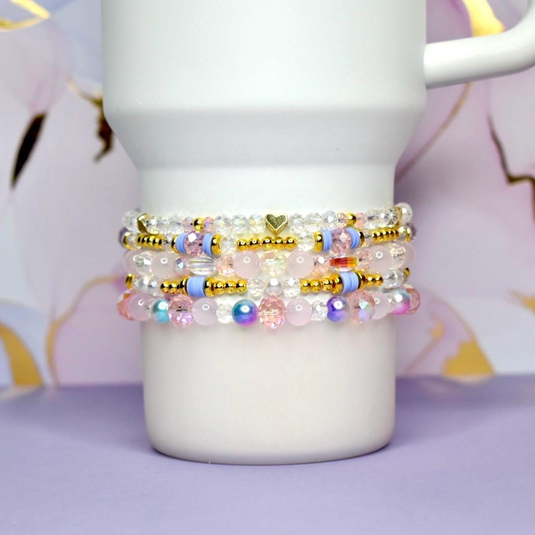 Stack of colorful beaded bracelets on a white mug with a soft focus background
