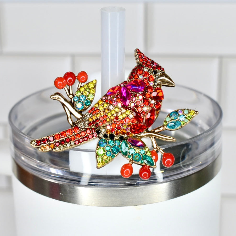 Colorful jeweled cardinal straw charm on a white Stanley tumbler against a white background