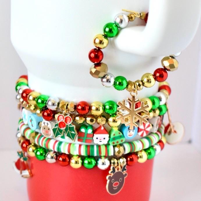 Colorful beaded bracelets with Christmas-themed charms on a mannequin arm.
