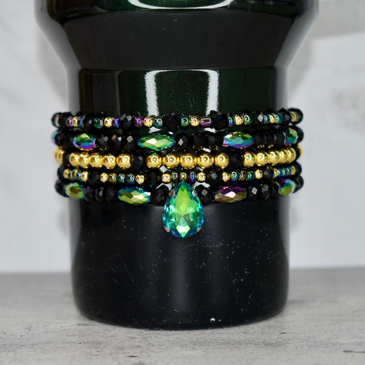 Stack of beaded bracelets with a teardrop gemstone on a Elphaba for Good Stanley.