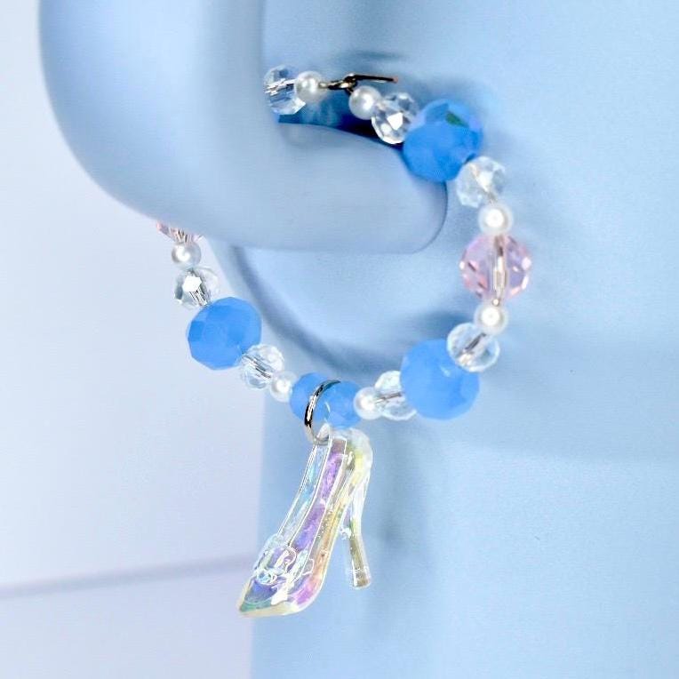 Beaded bracelet with a glass slipper charm on a blue background