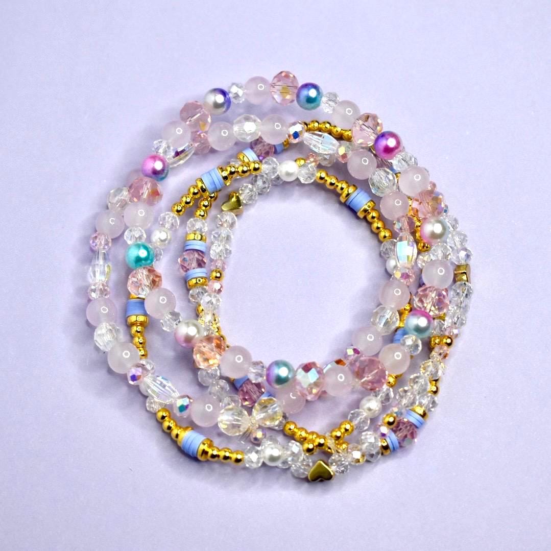 Set of colorful beaded bracelets on a light purple background