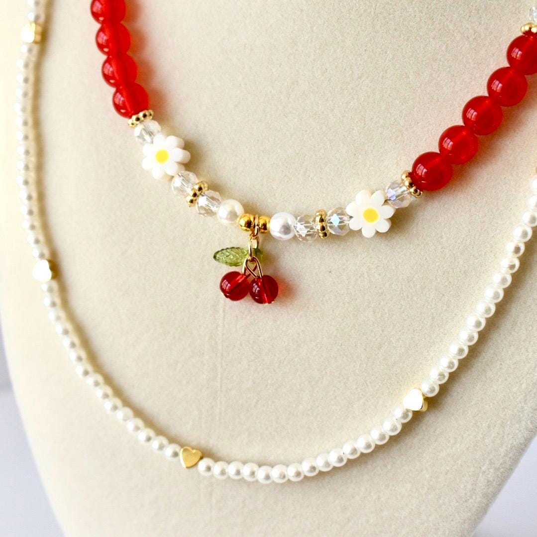 Layered necklace set.  One with pearls and cold hearts and the other with re white pearl and gold beads with a cherry charm.  Y2K jewelry set.