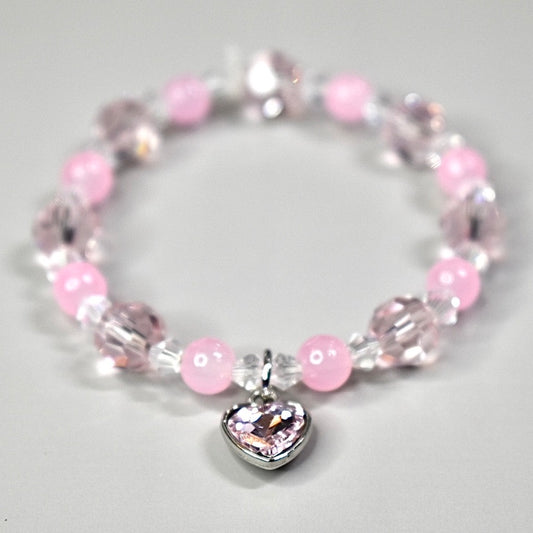 Bracelet with pink beads and a pink heart-shaped charm.