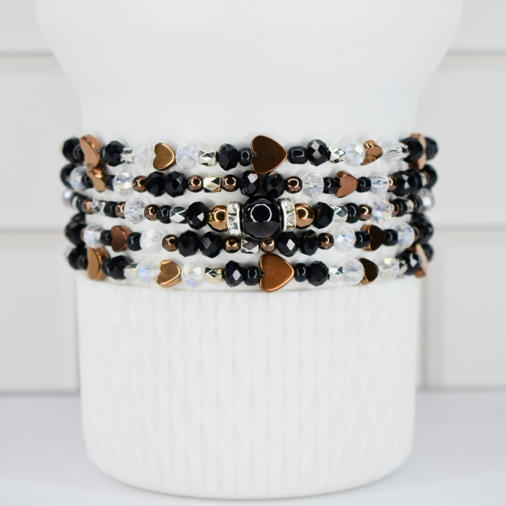 Stack of beaded bracelets on a white Sta key tumbler.