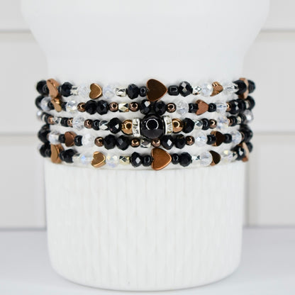 Stack of beaded bracelets on a white Sta key tumbler.