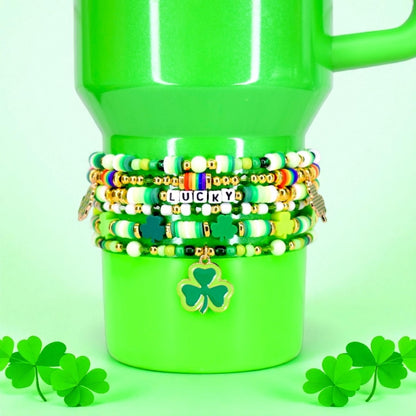 Green Stanley with colorful beaded bracelets and a shamrock charm on a green background