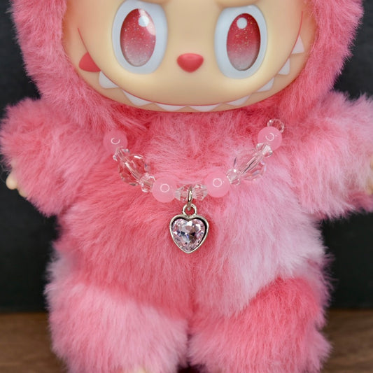 Pink Labubu with a heart-shaped charm.