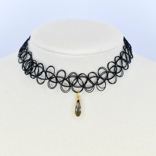 Black tattoo-style choker necklace with a gold pendant on a mannequin.