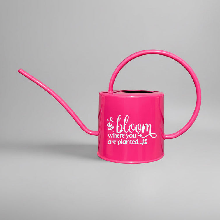 Hot pink watering can with bloom where you are planted in white on the front