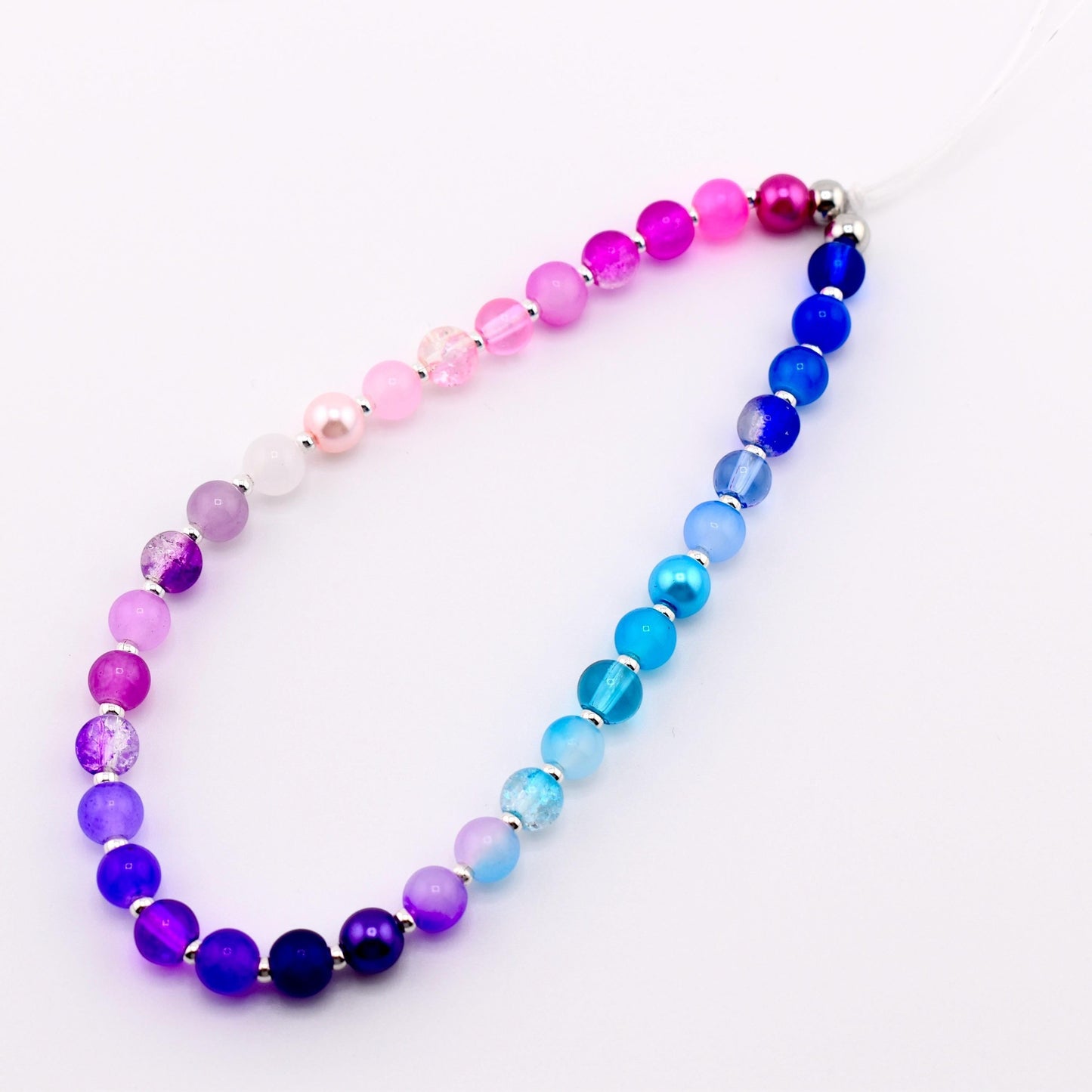 Calathea Collective pastel beaded phone charm wrist strap with pink, purple, and blue gradient glass beads and pearl accents.