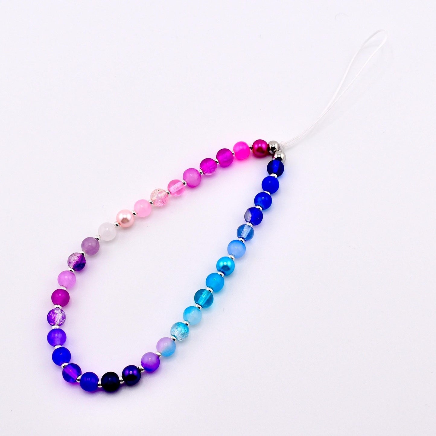 Calathea Collective beaded phone charm wrist strap with gradient of pink, purple, and blue glass beads and pearl accents.