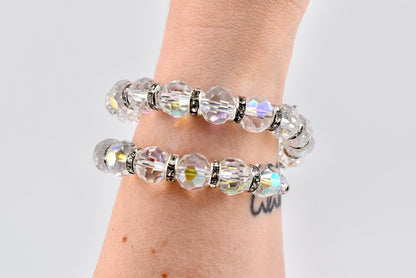 Calathea Collective iridescent crystal wrap bracelet with rhinestone spacer beads on a wrist. The bracelet has a subtle pink, blue, and gold shimmer.