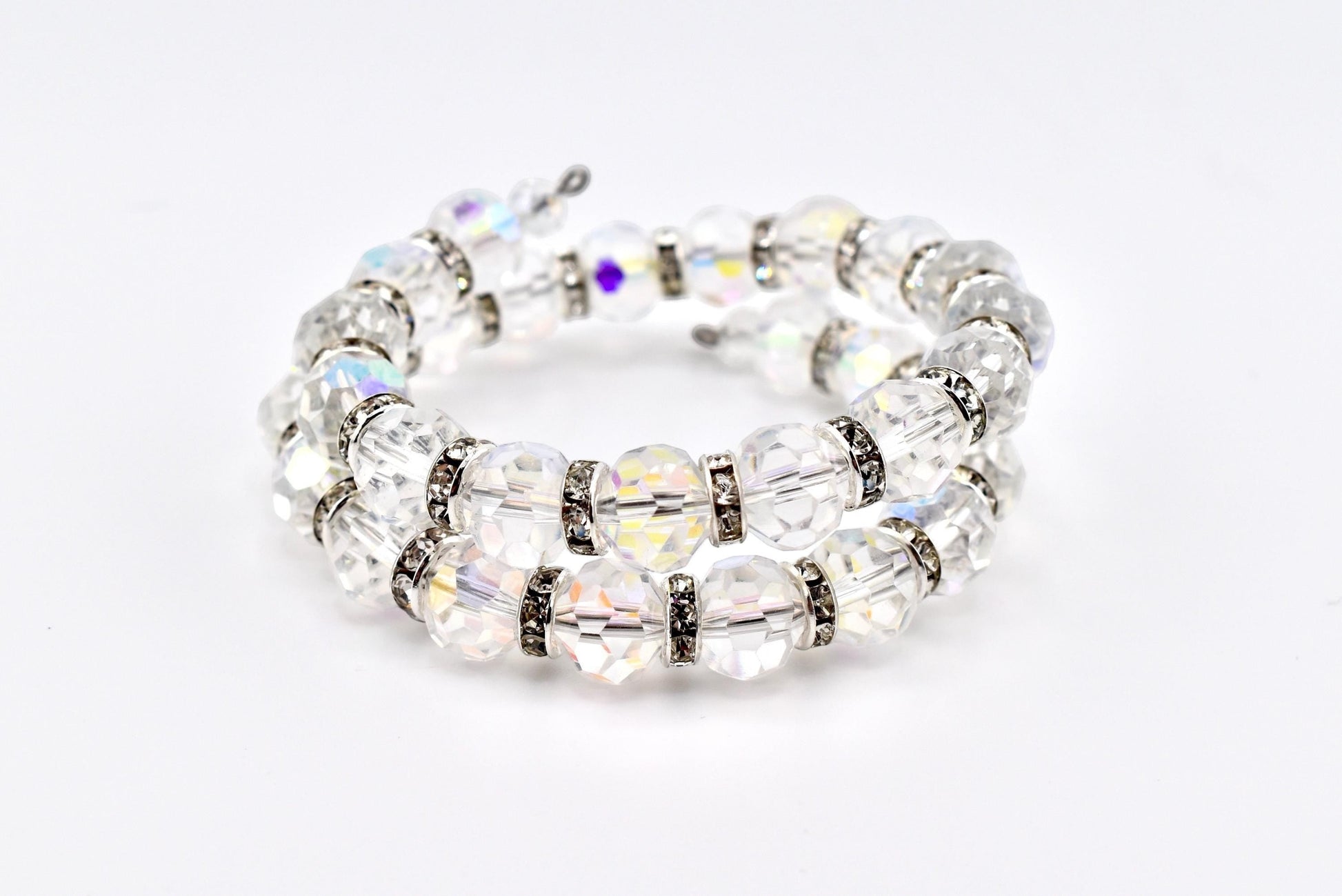 Calathea Collective iridescent crystal wrap bracelet with sparkling rhinestone spacer beads. Faceted AB finish crystals shimmer with pink, blue, and gold hues. Memory wire fits most wrists.