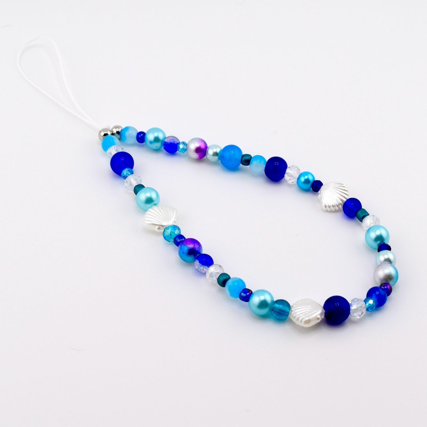 Calathea Collective ocean blue seashell phone charm wrist strap with pearl and glass beads.