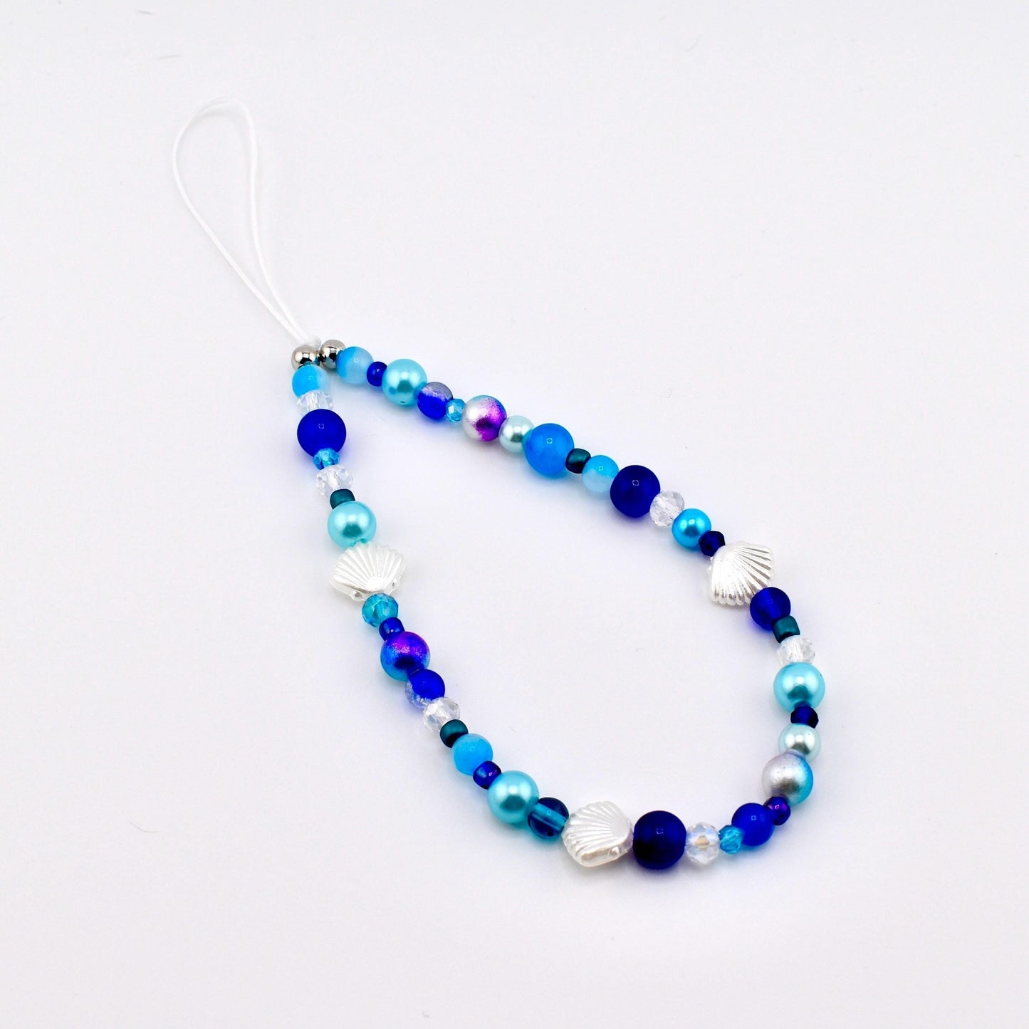 Calathea Collective ocean blue seashell phone charm wrist strap with pearl and glass beads, silver seashell accents.