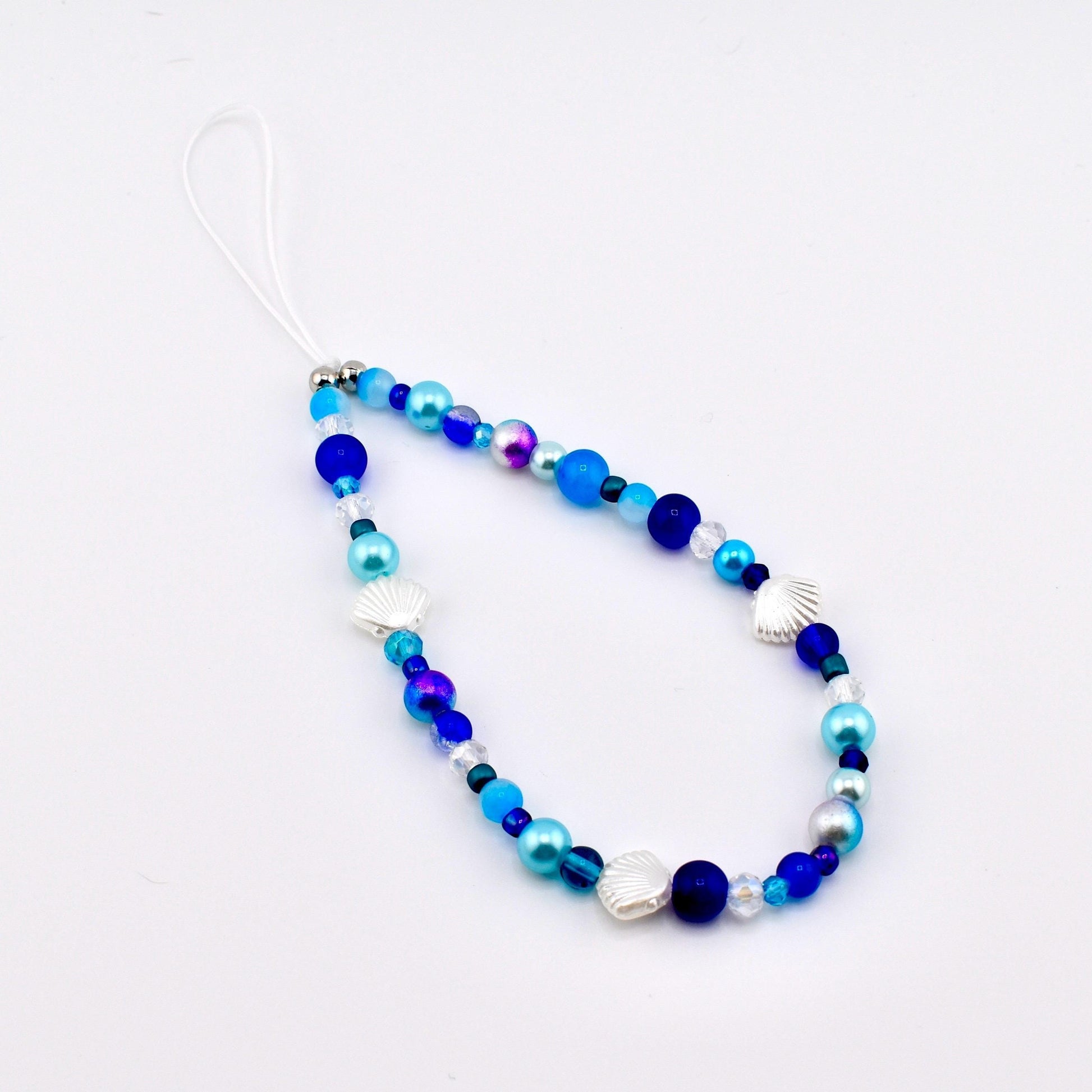 Calathea Collective ocean blue seashell phone charm wrist strap with pearl and glass beads, silver seashell accents.