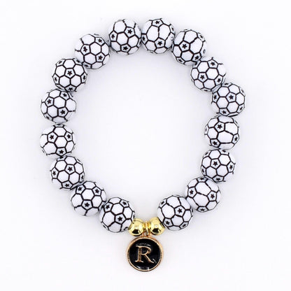 Calathea Collective soccer ball beaded bracelet with letter R charm and gold accent beads on a white background.