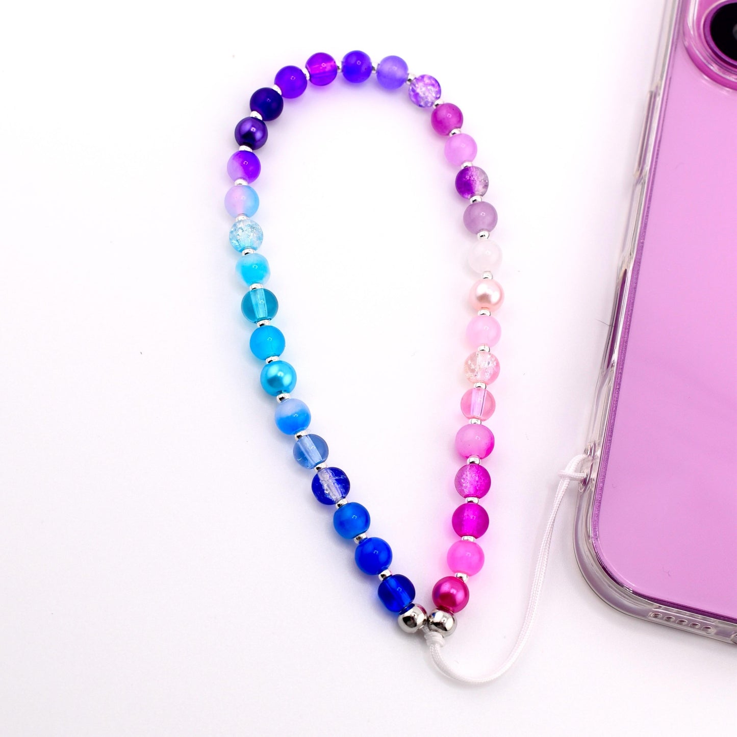 Calathea Collective beaded phone charm wrist strap with gradient of pink, purple, and blue glass beads and pearl accents.