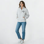 Calathea Collective light gray cropped oversized quarter zip sweatshirt with thumbholes and a front pouch pocket. Features black text logo on chest.