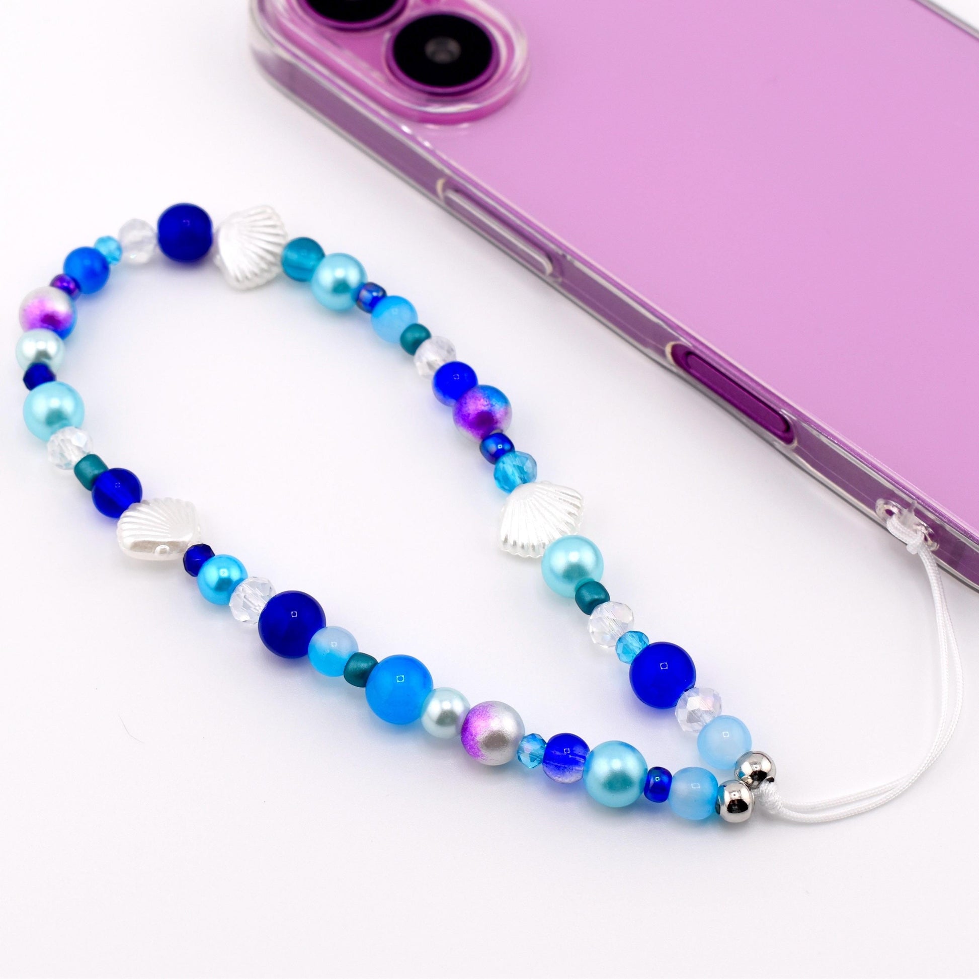 Calathea Collective ocean blue seashell phone charm wrist strap with pearl and glass beads, silver seashell accents.