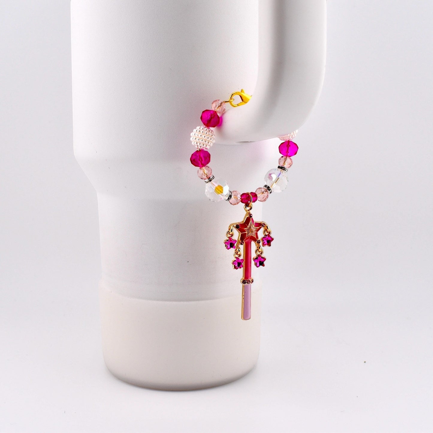 Calathea Collective pink star wand tumbler charm with fuchsia rhinestone stars, crystal beads, and pearl accents on a white tumbler handle.
