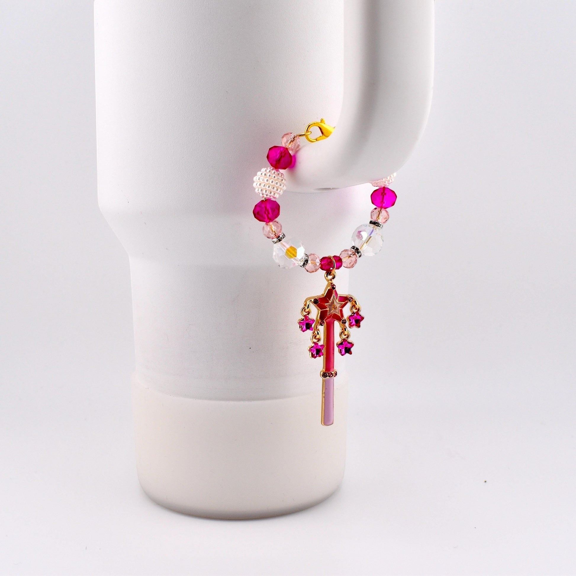 Calathea Collective pink star wand tumbler charm with fuchsia rhinestone stars, crystal beads, and pearl accents on a white tumbler handle.