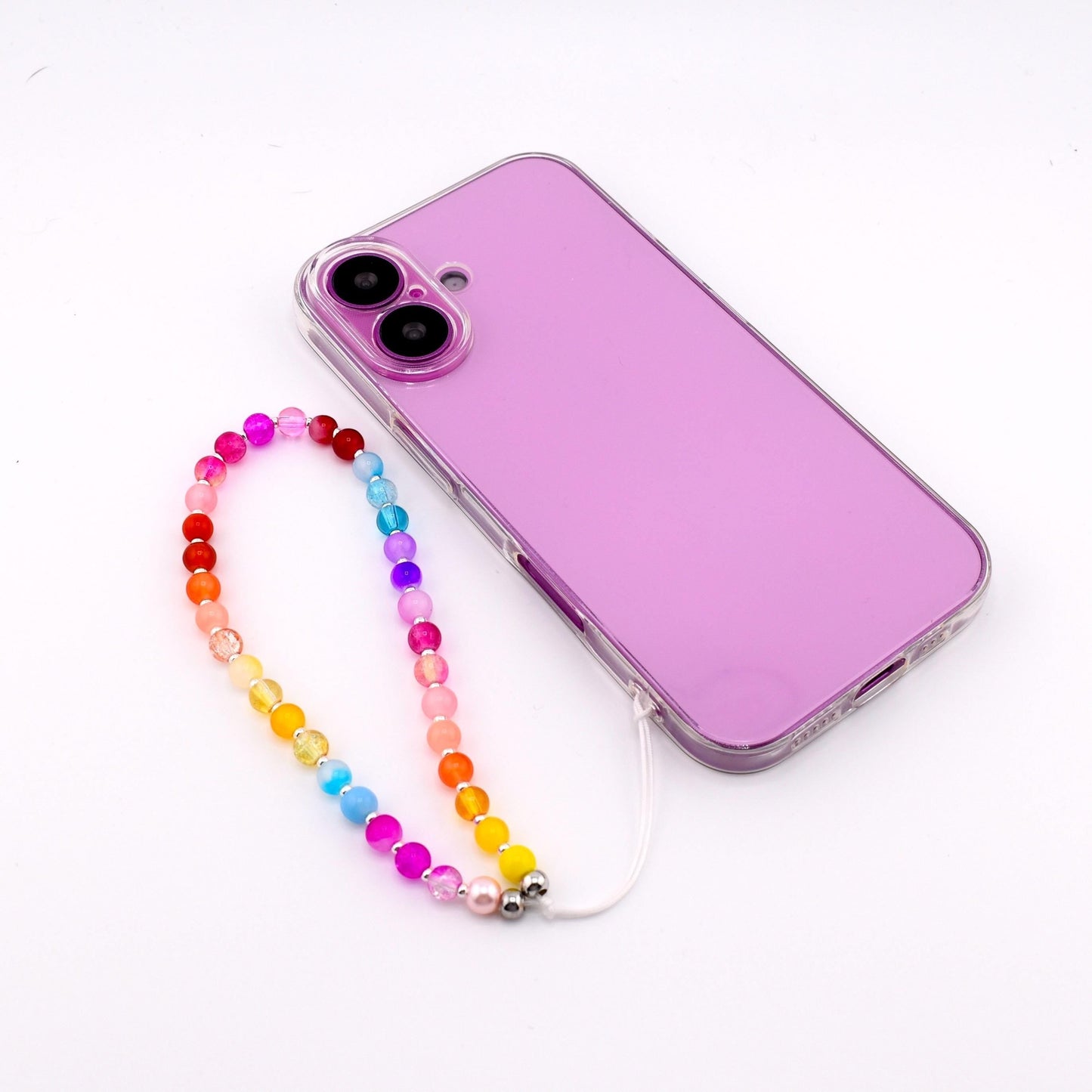 Calathea Collective rainbow beaded phone charm wrist strap with glass beads and silver spacers attached to a purple phone case.