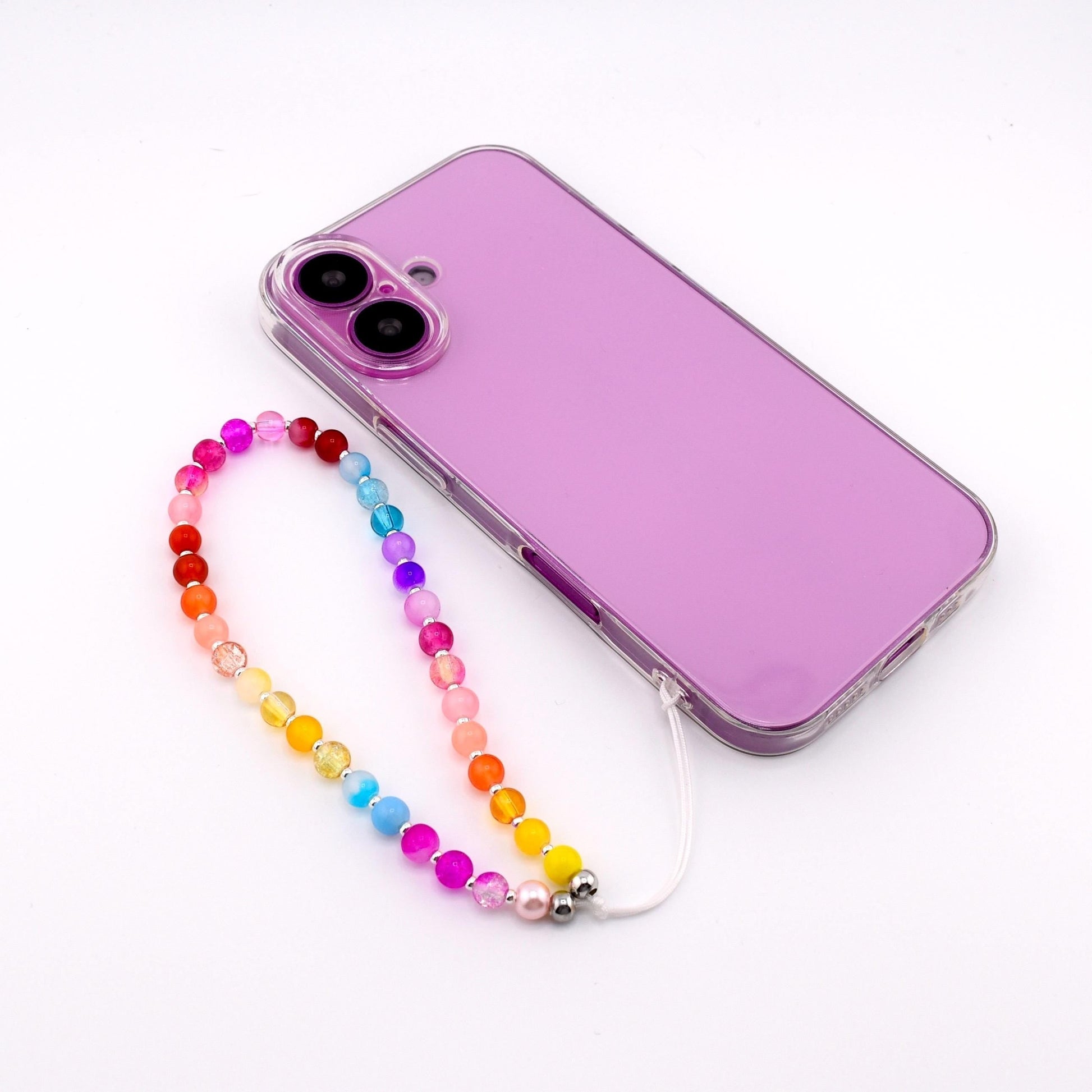 Calathea Collective rainbow beaded phone charm wrist strap made of glass beads and silver-tone spacers attached to a purple phone case.