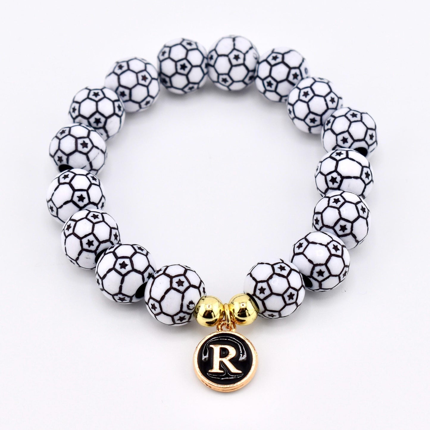 Calathea Collective soccer ball beaded bracelet with letter R charm and gold accent beads on a white background.
