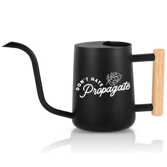 Black watering can with wooden handle and 'Don't Hate Propagate' text on a white background