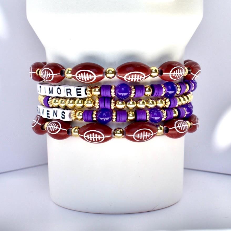 Stack of bracelets with football designs on a white Stanley tumbler