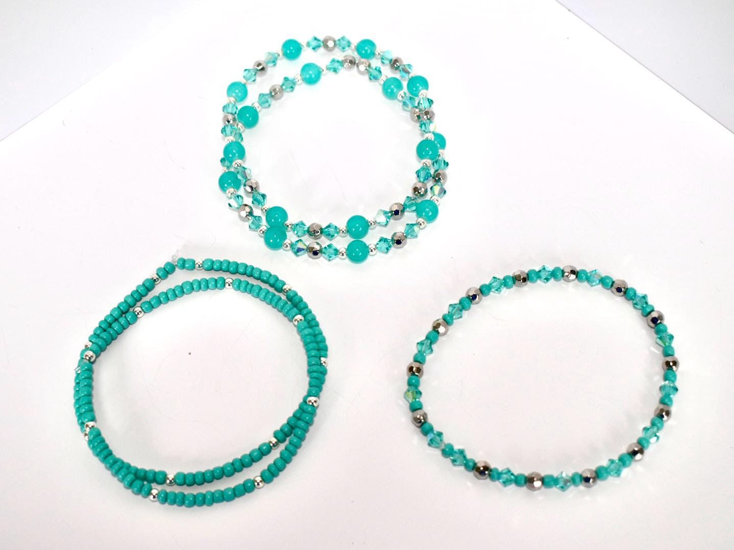 Set of turquoise beaded necklaces on a white background