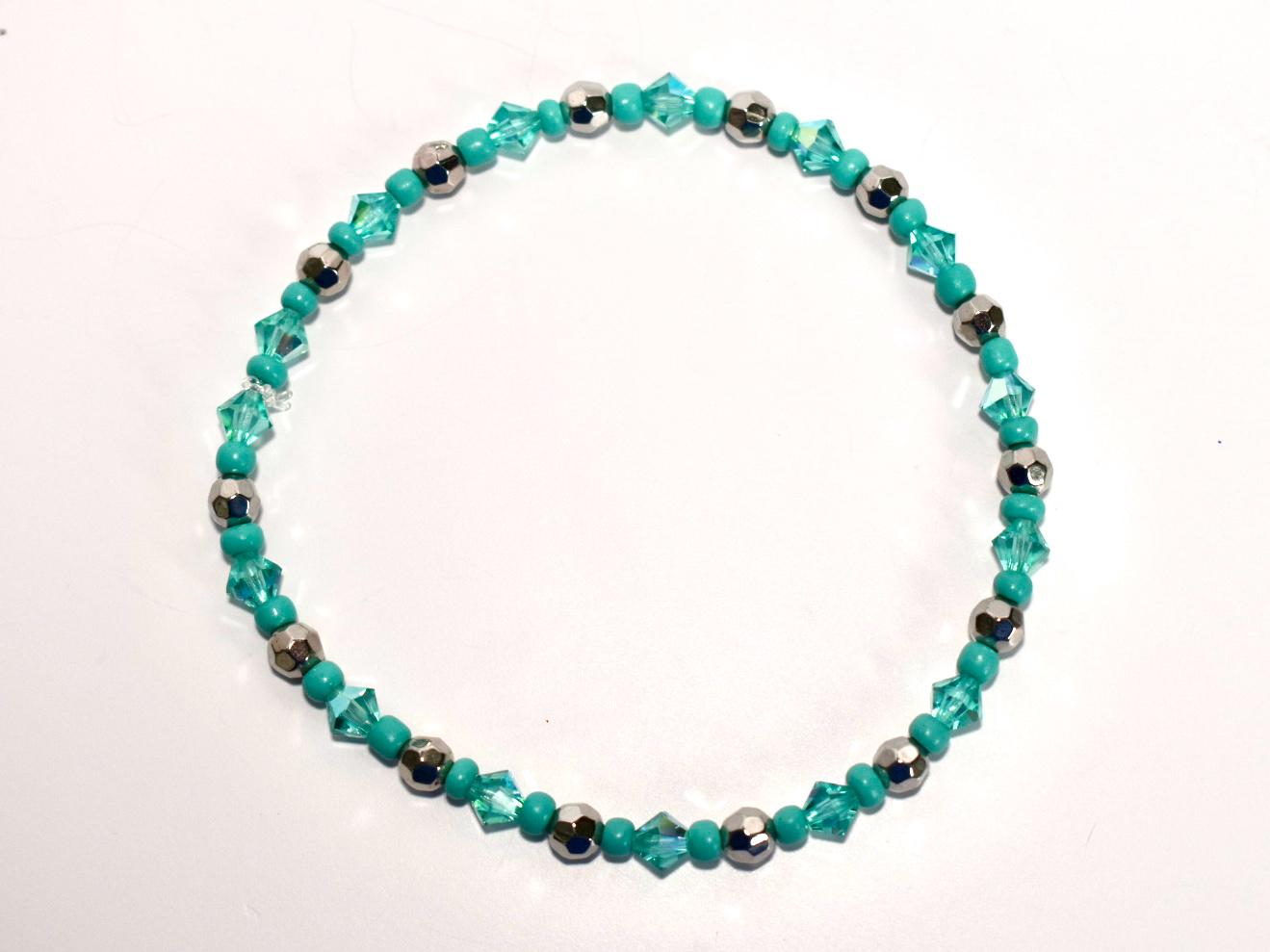 Turquoise and black beaded bracelet on a white background