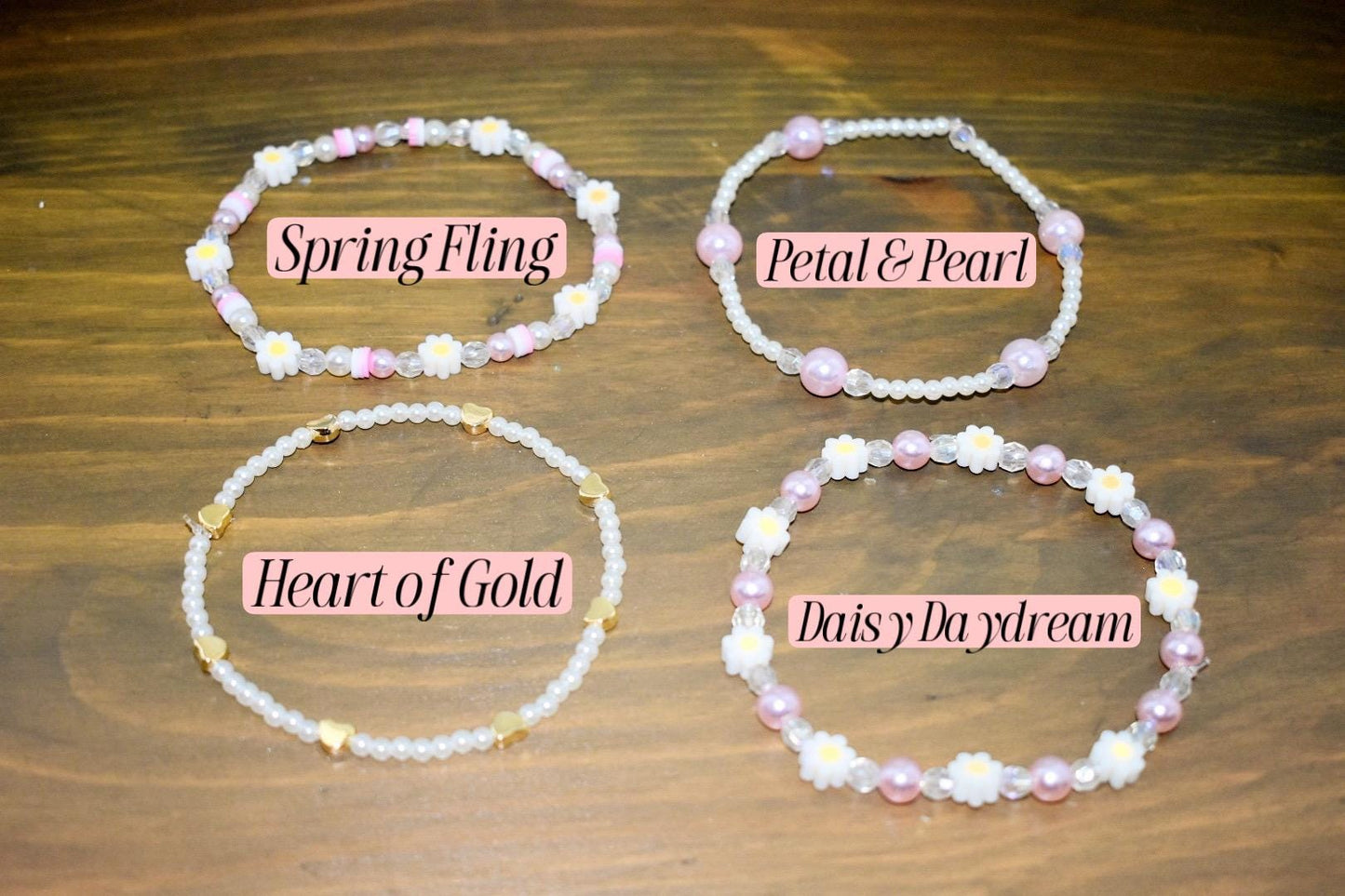 Four beaded bracelets with different designs and names. The bracelets are made with white beads and pink beads. The names of the bracelets are "Spring Fling", "Petal & Pearl", "Heart of Gold", and "Daisy Daydream".