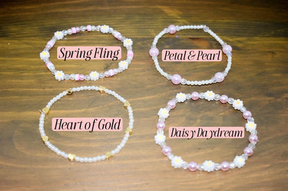 Four beaded bracelets with different designs and names. The bracelets are made with white beads and pink beads. The names of the bracelets are "Spring Fling", "Petal & Pearl", "Heart of Gold", and "Daisy Daydream".