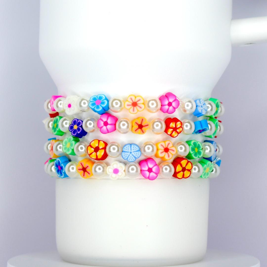 Bright colorful flower and pearl tumbler bracelet set with multicolor floral beads and white pearls, wrapped around a white tumbler.