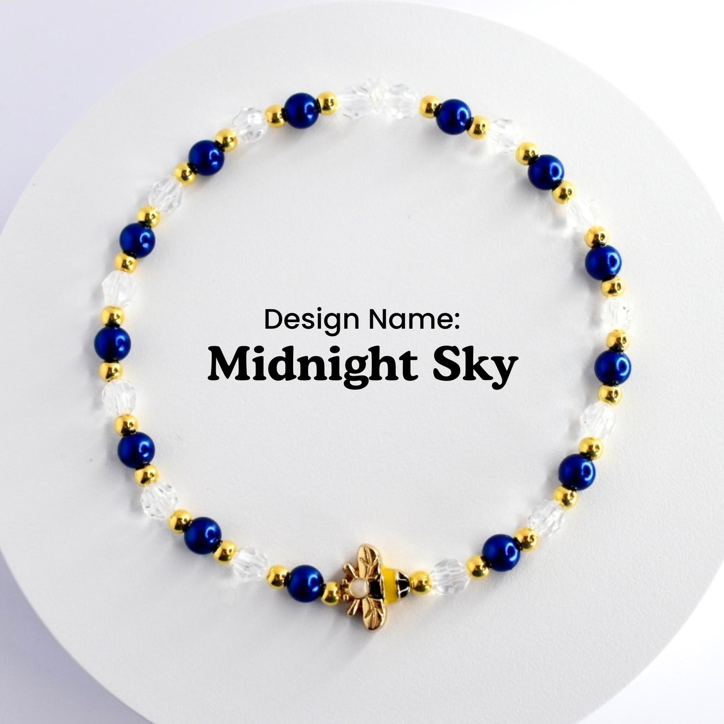 A blue and gold beaded bracelet with a bee charm. The bracelet is made with small blue and clear beads and gold spacers. The text 'Design Name: Midnight Sky' is visible in the center of the image.