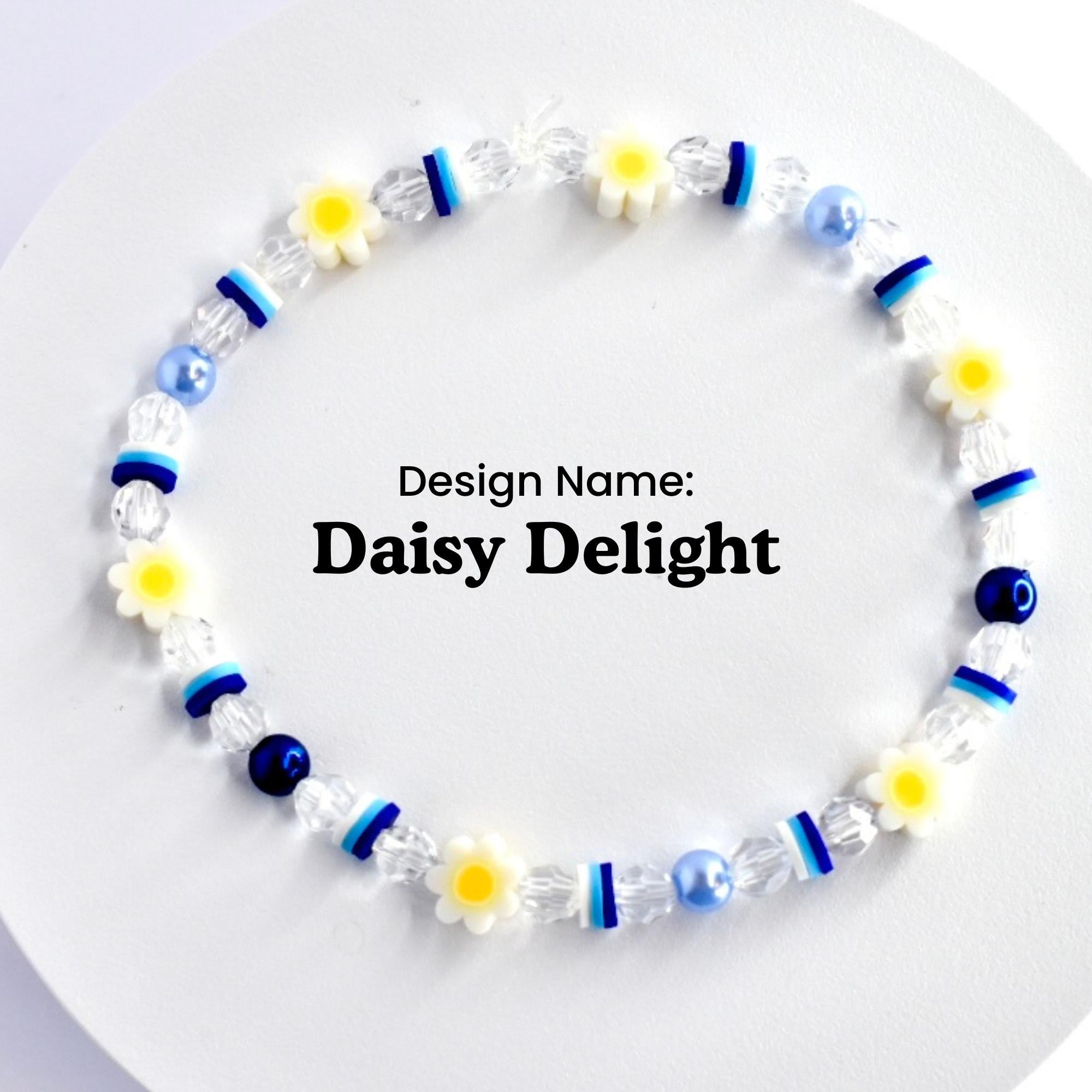 A white and blue beaded bracelet with white daisy charms. The bracelet is on a white surface. Design Name: Daisy Delight