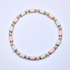 A pink and white beaded bracelet with gold accents. The bracelet is made of small, round beads and has a simple design.