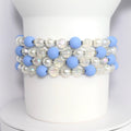 Four bracelets made of light blue and white beads. The bracelets feature alternating light blue matte beads and clear iridescent beads. The bracelet also includes white pearl beads.