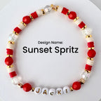A beaded bracelet with the text "Sunset Spritz." The bracelet features red, white, gold, and clear beads. The name "JACKI" is spelled out in white letter beads. The bracelet is designed with a mix of round and disc-shaped beads.