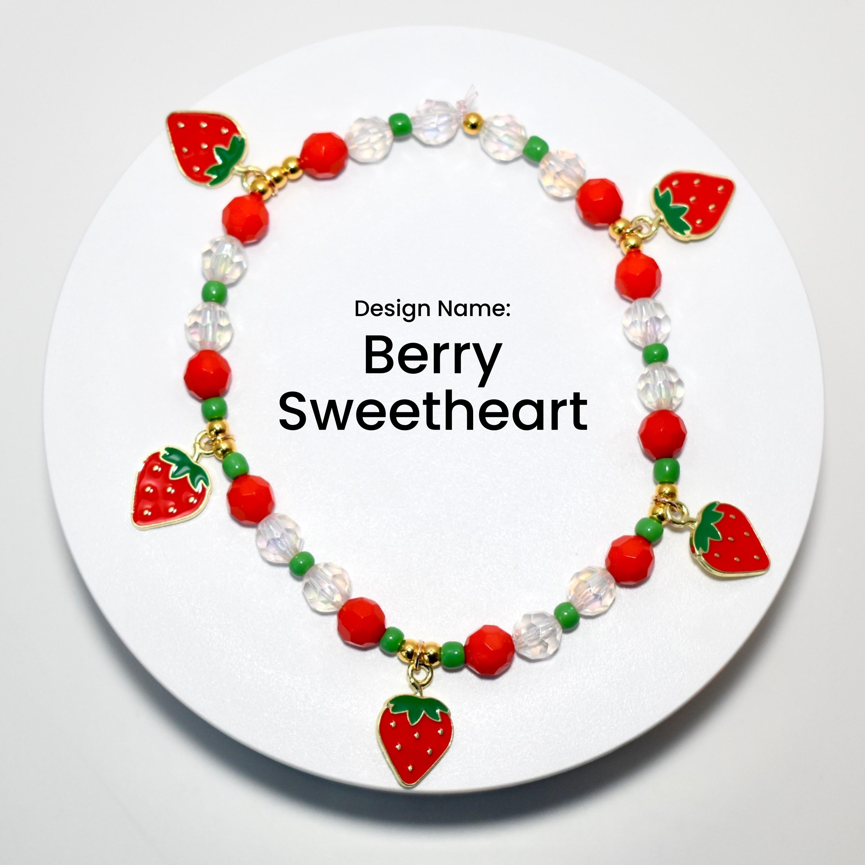 A red and green beaded bracelet with strawberry charms. The bracelet has a white background with the text 'Design Name: Berry Sweetheart'.