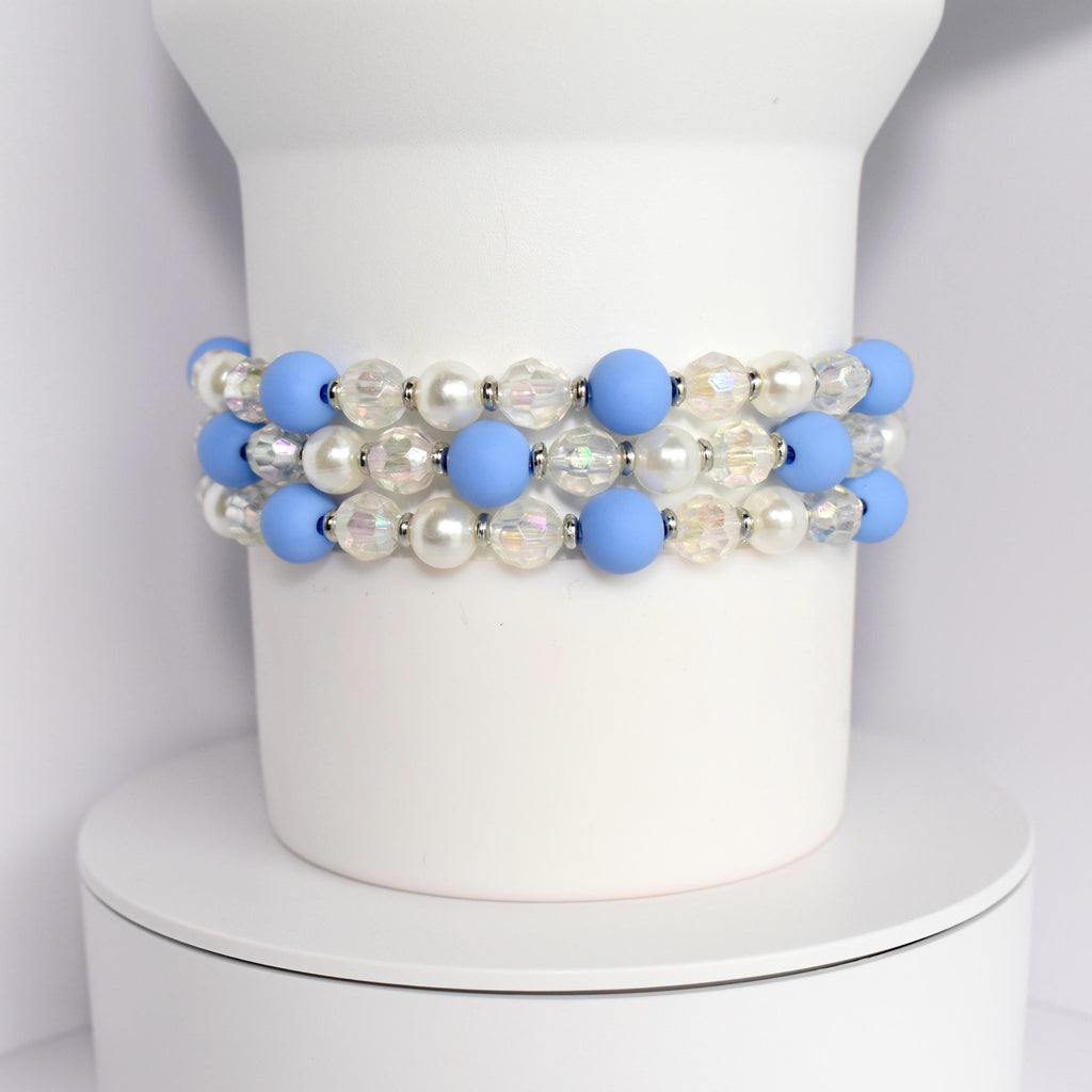 A layered bracelet with blue, white, and iridescent beads