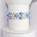 A layered bracelet with blue, white, and iridescent beads