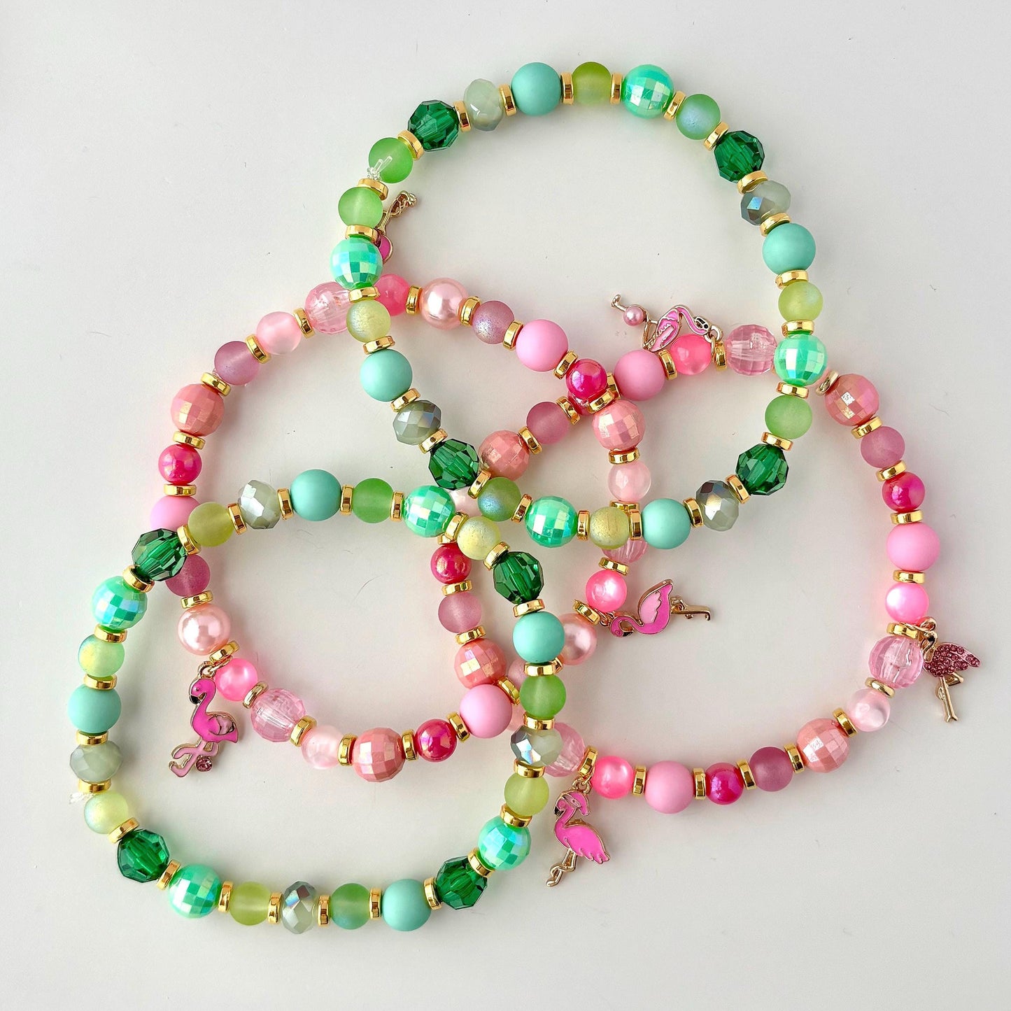 Tropical tumbler bracelet stack with pink and green beads, gold spacers, and flamingo charms, perfect for summer cup jewelry or tropical-themed drinkware decor.