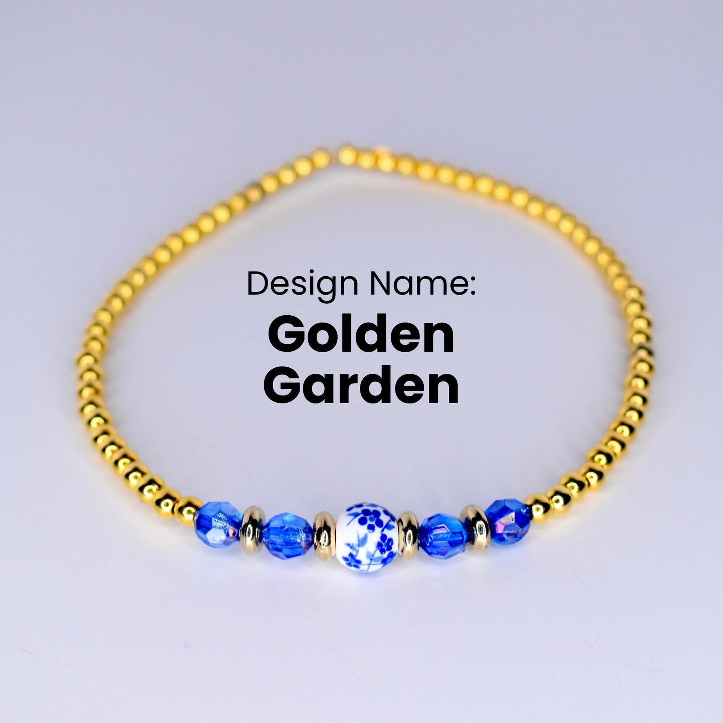 A gold beaded bracelet with a blue and white porcelain bead in the center. The bracelet is on a white background. Design Name: Golden Garden